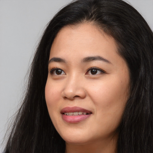 Joyful asian young-adult female with long  brown hair and brown eyes