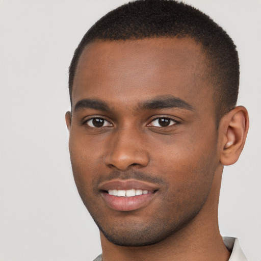 Joyful black young-adult male with short  brown hair and brown eyes