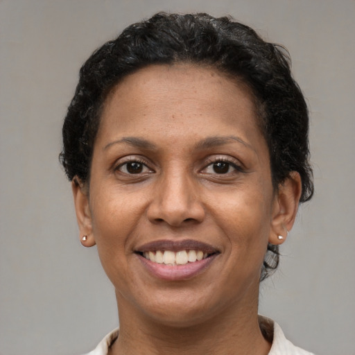 Joyful latino adult female with short  brown hair and brown eyes