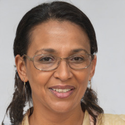 Joyful latino adult female with medium  brown hair and brown eyes