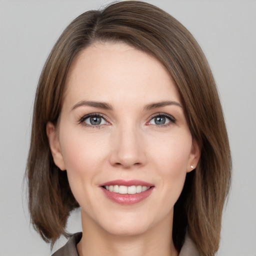 Joyful white young-adult female with medium  brown hair and grey eyes