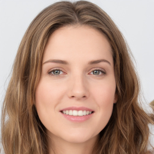 Joyful white young-adult female with long  brown hair and green eyes