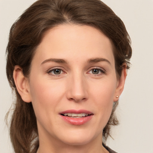 Joyful white young-adult female with medium  brown hair and grey eyes