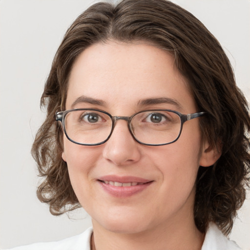 Joyful white young-adult female with medium  brown hair and green eyes