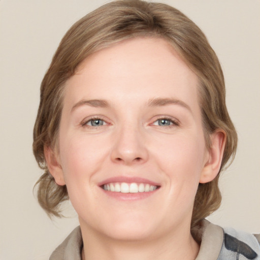 Joyful white young-adult female with medium  brown hair and blue eyes