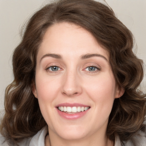 Joyful white young-adult female with long  brown hair and green eyes