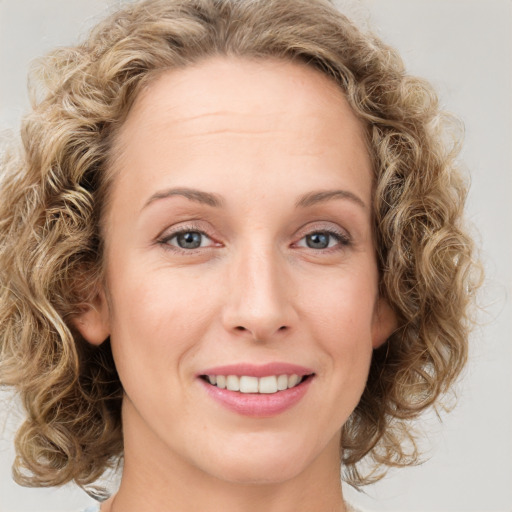 Joyful white young-adult female with medium  brown hair and blue eyes