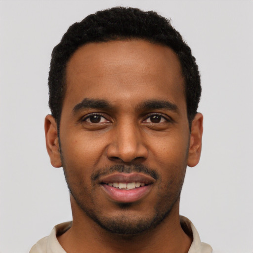 Joyful black young-adult male with short  black hair and brown eyes