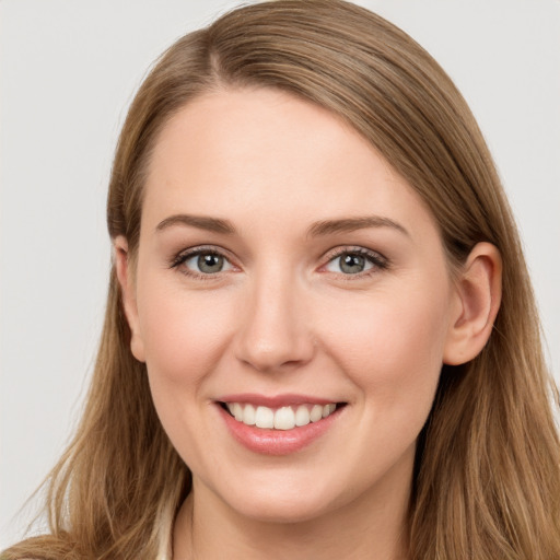 Joyful white young-adult female with long  brown hair and grey eyes