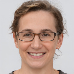 Joyful white adult female with medium  brown hair and grey eyes