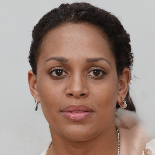 Joyful black young-adult female with short  brown hair and brown eyes