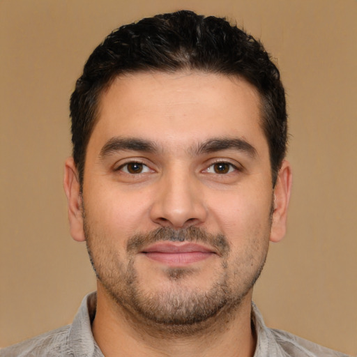 Joyful latino young-adult male with short  brown hair and brown eyes