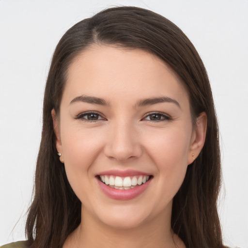 Joyful white young-adult female with long  brown hair and brown eyes