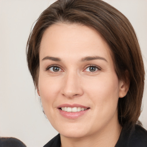 Joyful white young-adult female with medium  brown hair and grey eyes