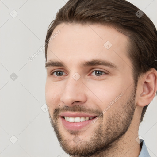 Joyful white young-adult male with short  brown hair and grey eyes