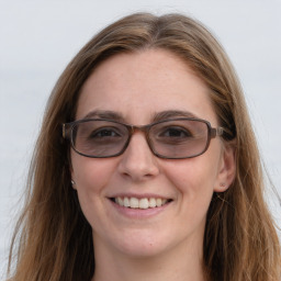 Joyful white young-adult female with long  brown hair and blue eyes