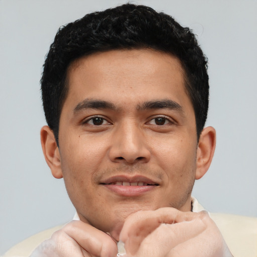 Joyful latino young-adult male with short  brown hair and brown eyes