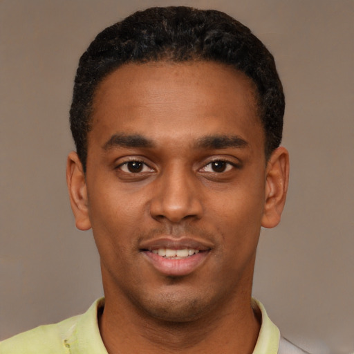 Joyful black young-adult male with short  black hair and brown eyes