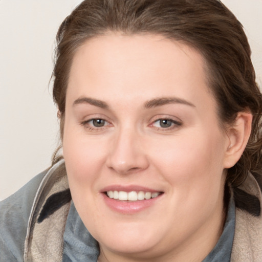 Joyful white young-adult female with medium  brown hair and grey eyes