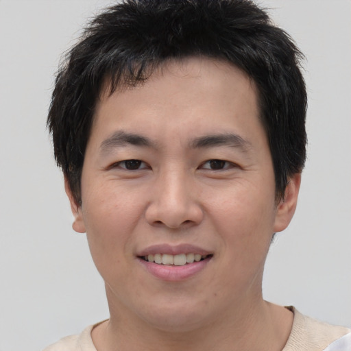 Joyful asian young-adult male with short  brown hair and brown eyes