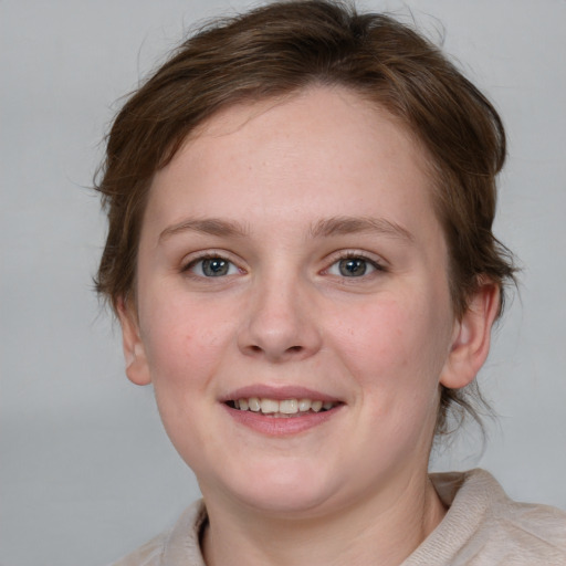 Joyful white young-adult female with medium  brown hair and grey eyes