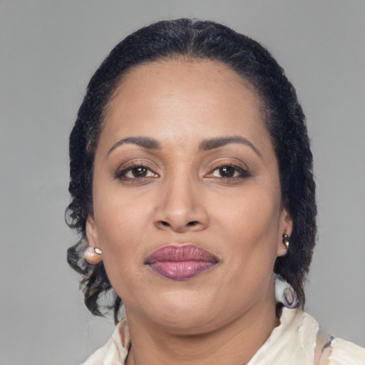 Joyful latino adult female with medium  brown hair and brown eyes