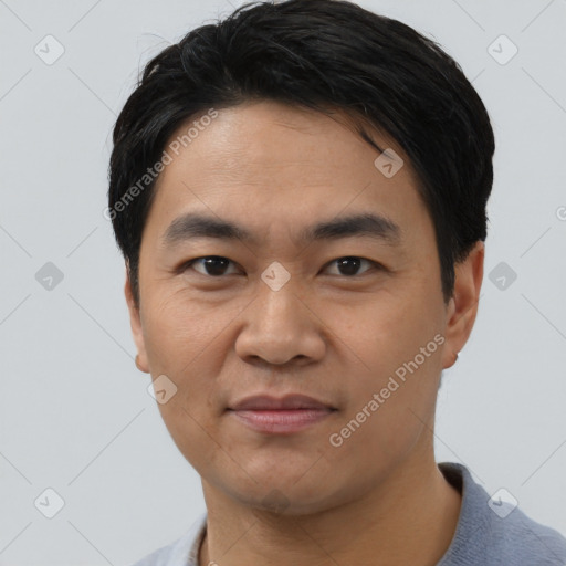 Joyful asian young-adult male with short  black hair and brown eyes