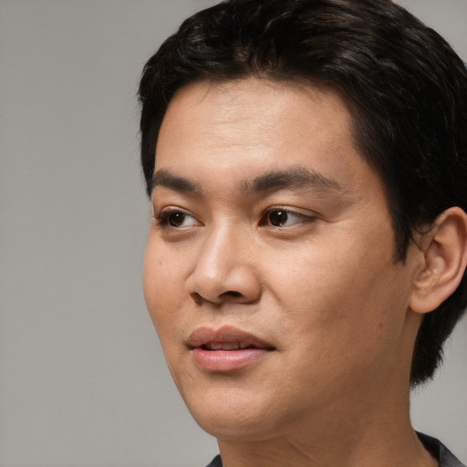Joyful asian young-adult male with short  black hair and brown eyes