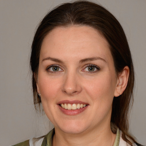 Joyful white young-adult female with medium  brown hair and grey eyes