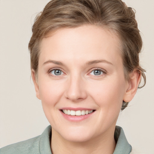 Joyful white young-adult female with medium  brown hair and blue eyes