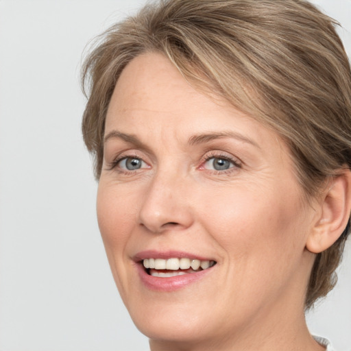 Joyful white adult female with medium  brown hair and grey eyes