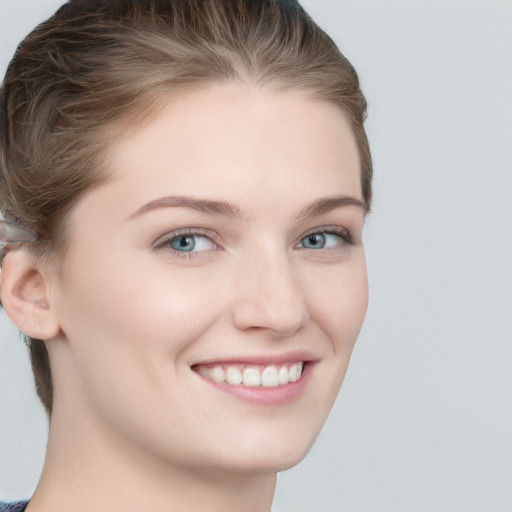 Joyful white young-adult female with short  brown hair and blue eyes