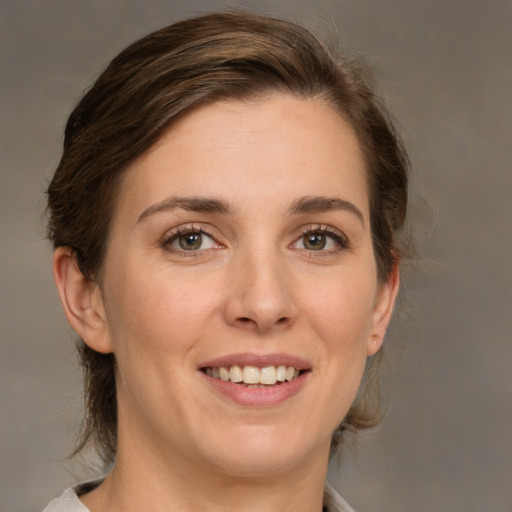 Joyful white young-adult female with medium  brown hair and green eyes