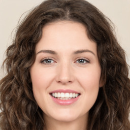 Joyful white young-adult female with long  brown hair and green eyes