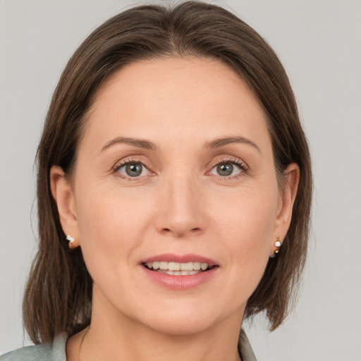 Joyful white adult female with medium  brown hair and grey eyes