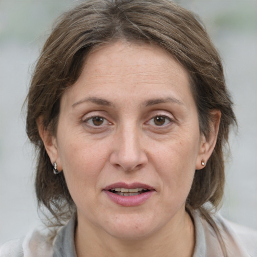 Joyful white adult female with medium  brown hair and grey eyes