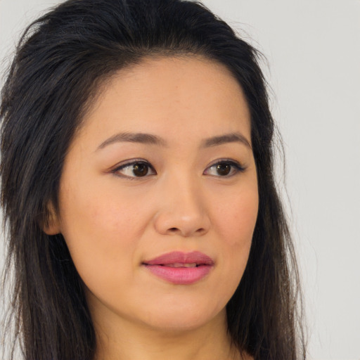 Joyful asian young-adult female with long  brown hair and brown eyes