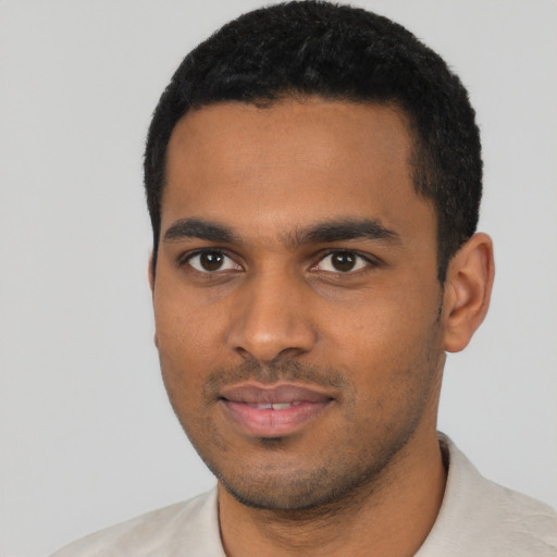 Joyful black young-adult male with short  black hair and brown eyes