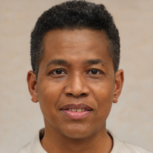 Joyful black adult male with short  black hair and brown eyes