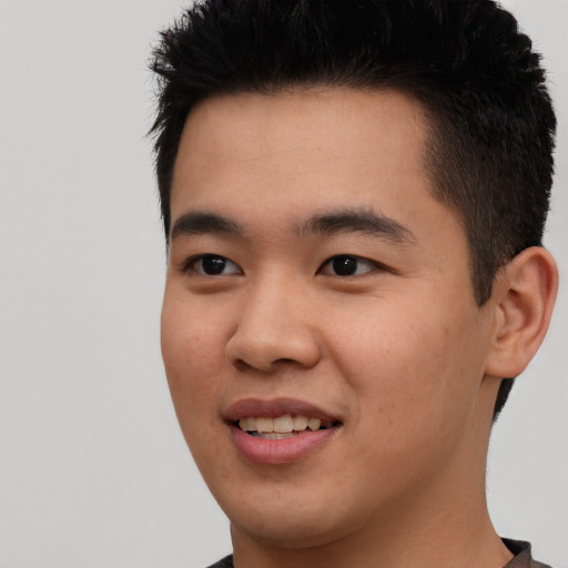 Joyful asian young-adult male with short  black hair and brown eyes
