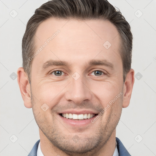 Joyful white young-adult male with short  brown hair and grey eyes