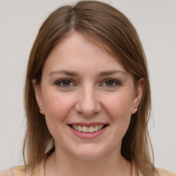 Joyful white young-adult female with medium  brown hair and grey eyes