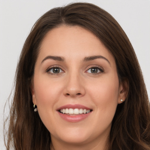 Joyful white young-adult female with long  brown hair and grey eyes