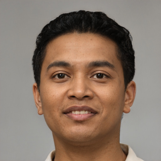 Joyful latino young-adult male with short  black hair and brown eyes