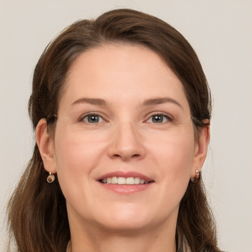 Joyful white young-adult female with long  brown hair and grey eyes