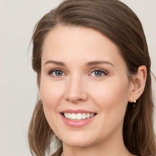 Joyful white young-adult female with long  brown hair and grey eyes