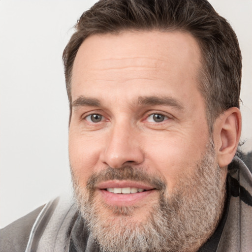 Joyful white adult male with short  brown hair and brown eyes