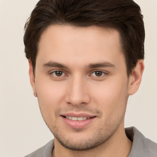 Joyful white young-adult male with short  brown hair and brown eyes