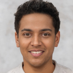 Joyful latino young-adult male with short  brown hair and brown eyes