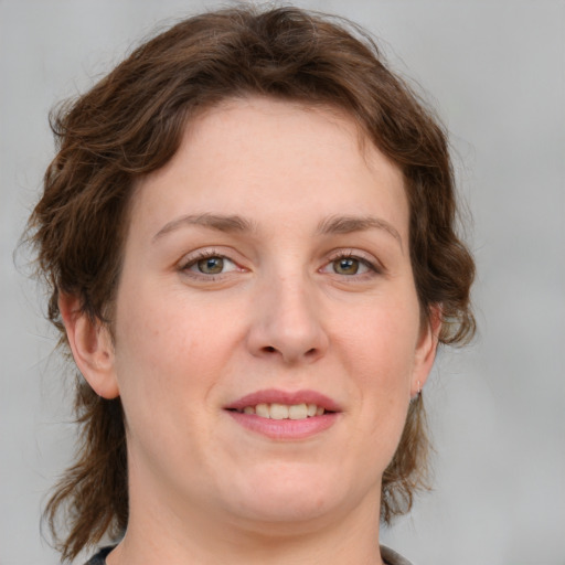 Joyful white young-adult female with medium  brown hair and green eyes